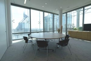 Photo de présentation de l'aménagement d'un espace de réunion ergonomique grâce à sa grande table de réunion ronde pour faciliter le dialogue dans les bureaux de Saint-Gobain à Paris La Défense.