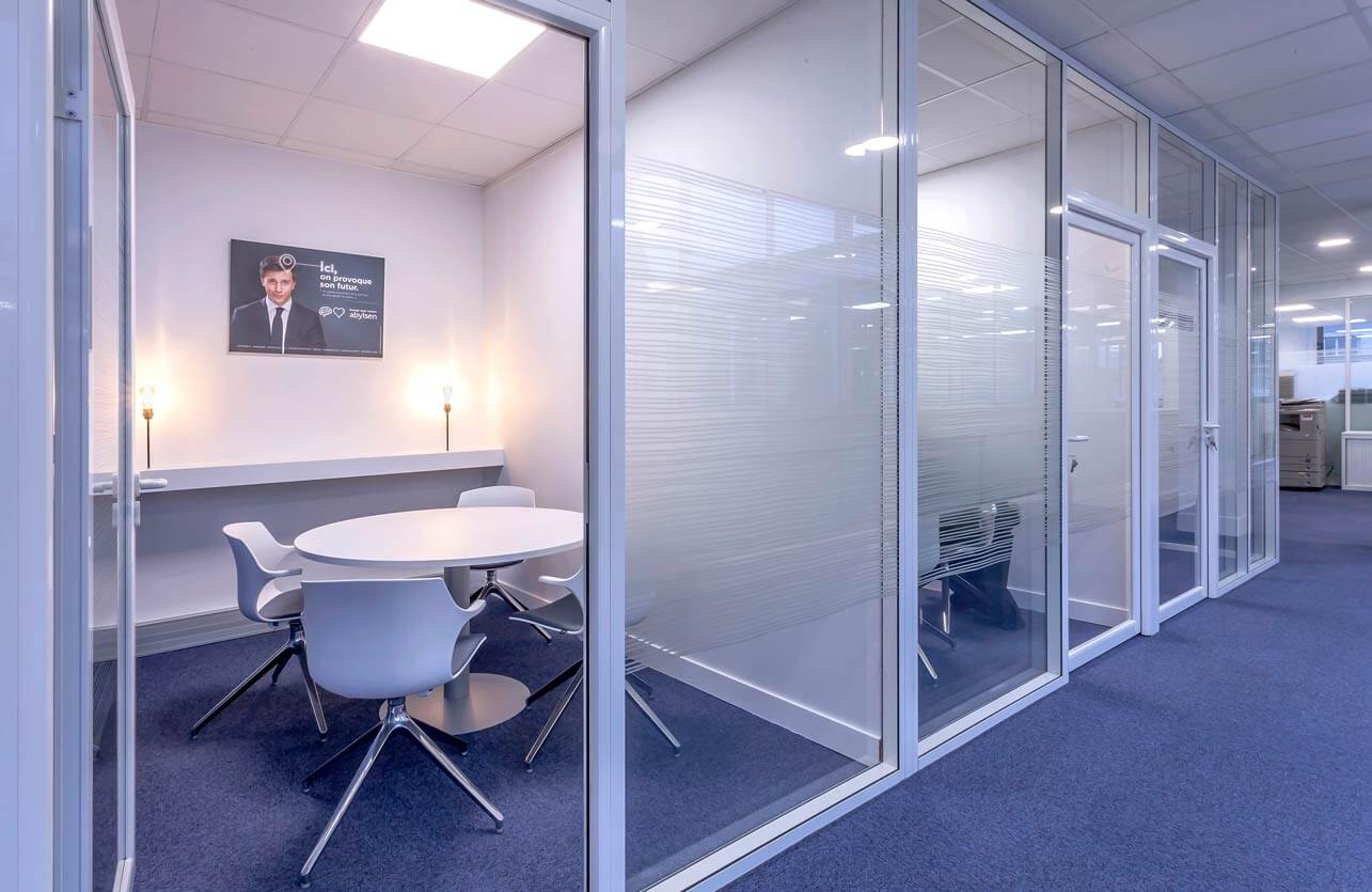 Photo de présentation de l'aménagement de plusieurs salles de travail collectif avec cloisons vitrées dans les bureaux de Abylsen aux Champs-Elysées (Paris)