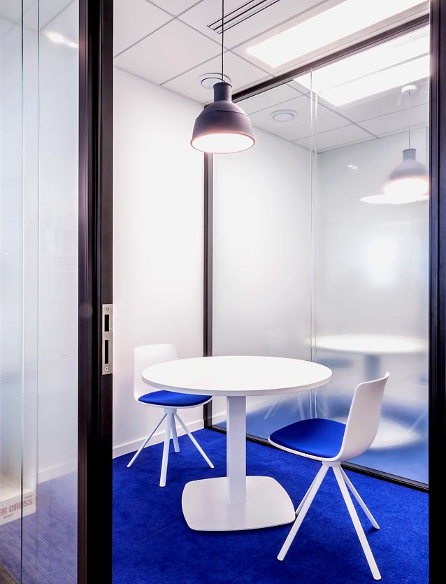 Photo de présentation de l'aménagement d'une salle de réunion équipée d'une table ronde pour les bureaux de Média-Participations à Paris