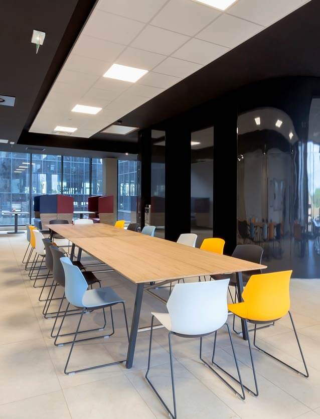 Photo de présentation de l'aménagement d'une grande table dans la salle de détente des bureaux de Kawneer à Montpellier