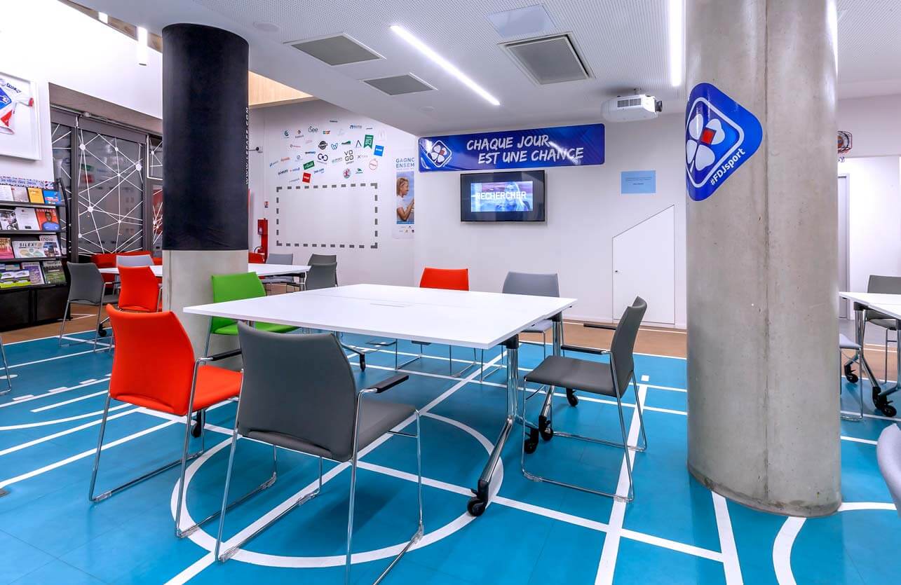 Photo de présentation de l'aménagement d'une grande table favorisant l'esprit d'équipe dans les bureaux de la startup Jean Bouin "Le Tremplin" à Paris